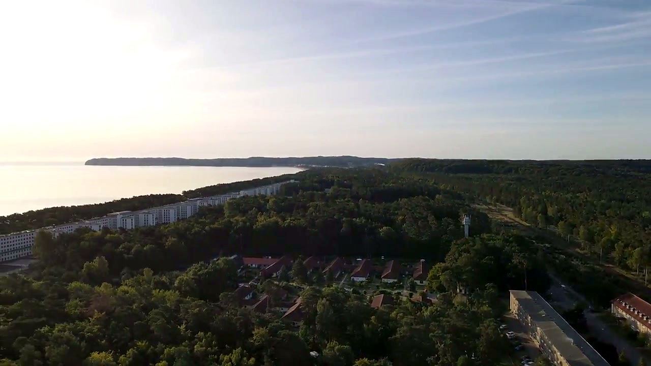 Luftaufnahme über Prora: Kiefernwald, Gebäudezeile und dahinter der Strand der Prorer Wiek